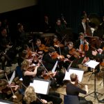 Herr Eschbach dirigiert den „vollen Klangkörper der Symphoniker“ (AZ) des ASO